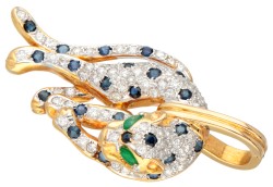 18 kt. Bicolor gouden panter hanger bezet met ca. 0.71 ct. diamant, ca. 0.69 ct. natuurlijk saffier en ca. 0.04 ct. natuurlijk smaragd.
